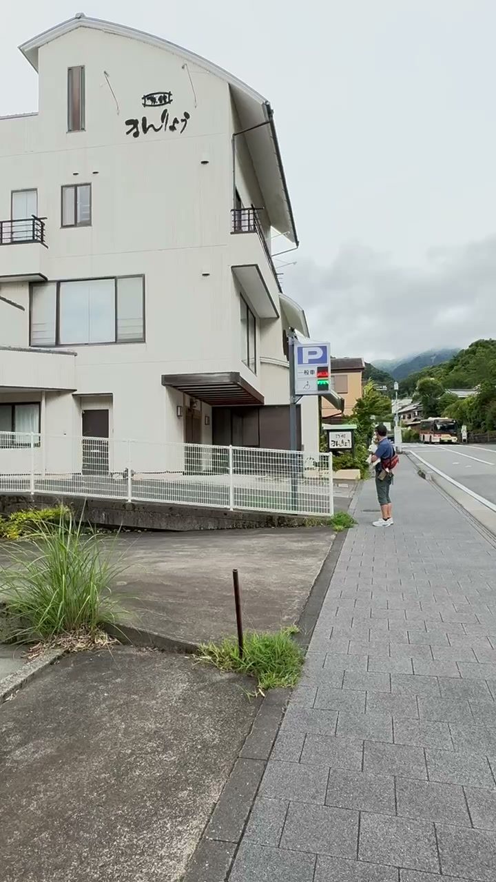 旅館まんりょうの建物と青いP一般車の看板