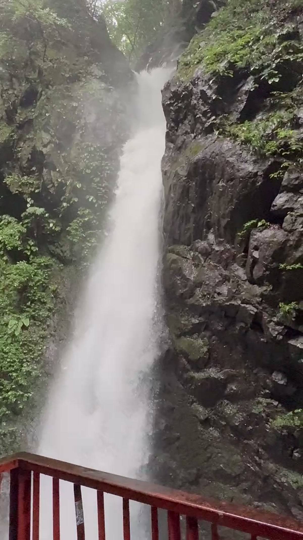 赤い欄干の向こうに落ちる塩川滝の全景